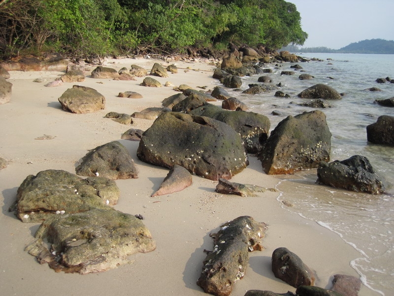 แนวหาดทรายที่น้ำลดลงพอเดินสะดวก สลับก้อนหินและโขดหิน